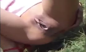 Sexy brunette shitting in a park behind a tree