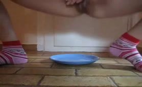 Shaved girl pooping on a plate