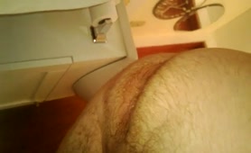 Hairy guy shitting over the toilet