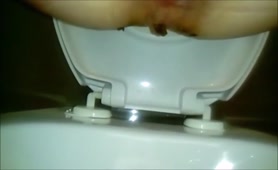 Sexy babe shitting a long turd in the toilet